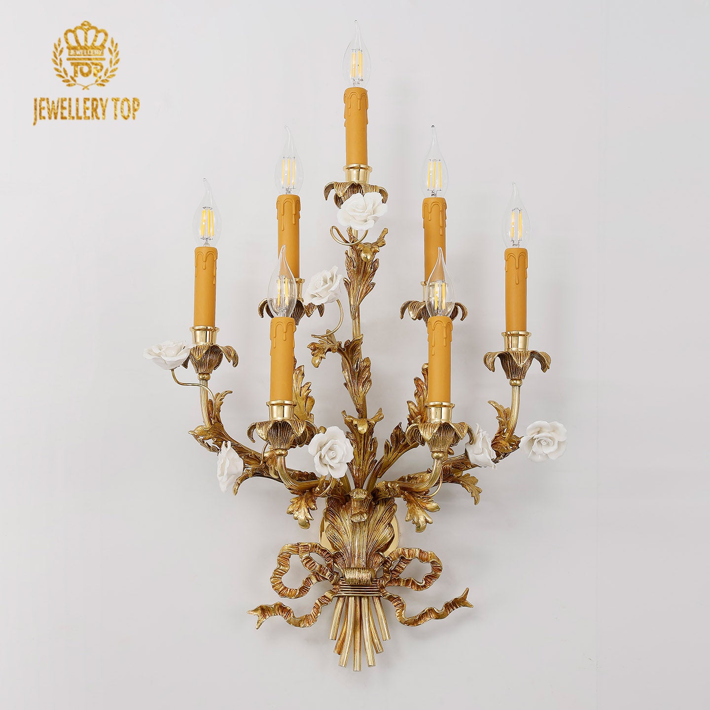Front product view of the golden seven-arm French wall lamp with ornate metalwork and glowing bulbs, isolated on white.