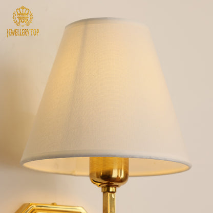 Detailed macro shot of the sconce’s brushed metal octagon base and polished brass arm connection.