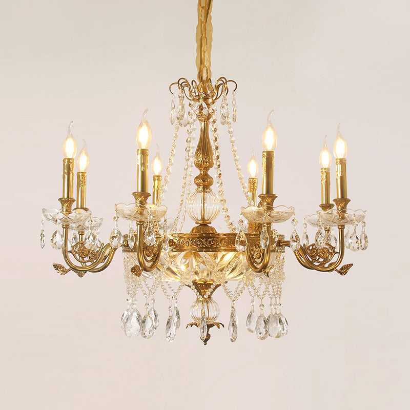 Golden brass and crystal chandelier with glass shade, isolated on a plain background.