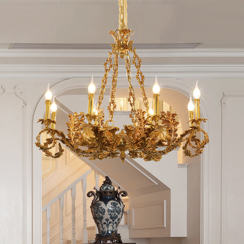 The brass chandelier installed in an elegant hallway with wainscoting and a staircase.