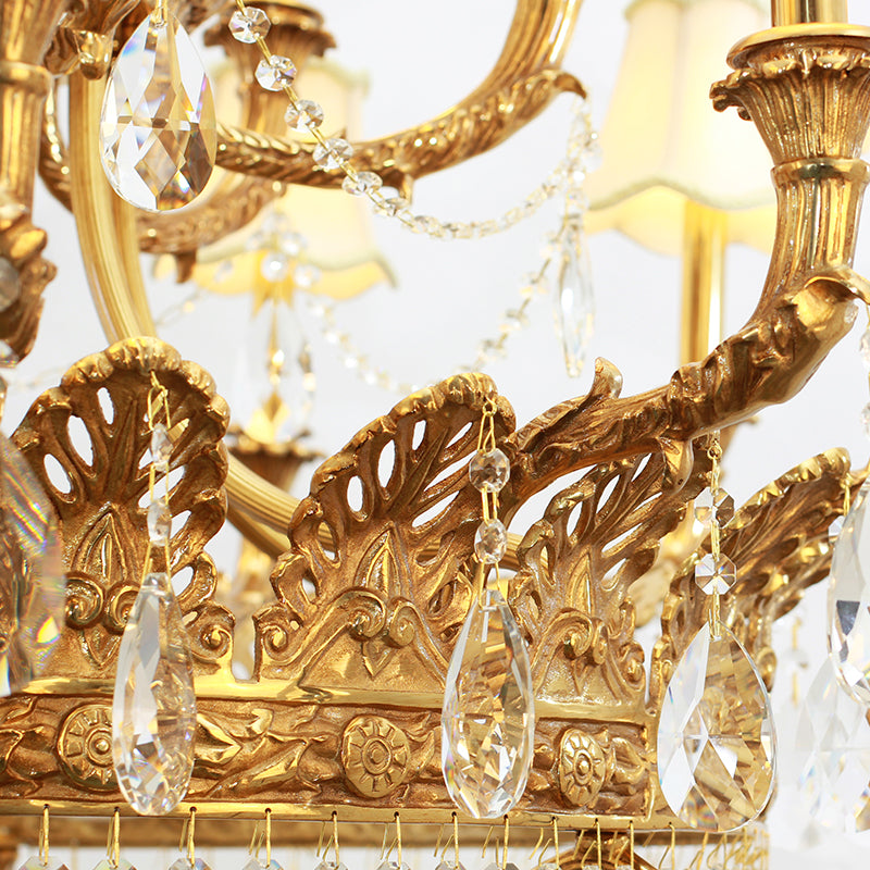 Macro shot of intricate brass scrollwork and hanging crystal decorations on a luxury chandelier.