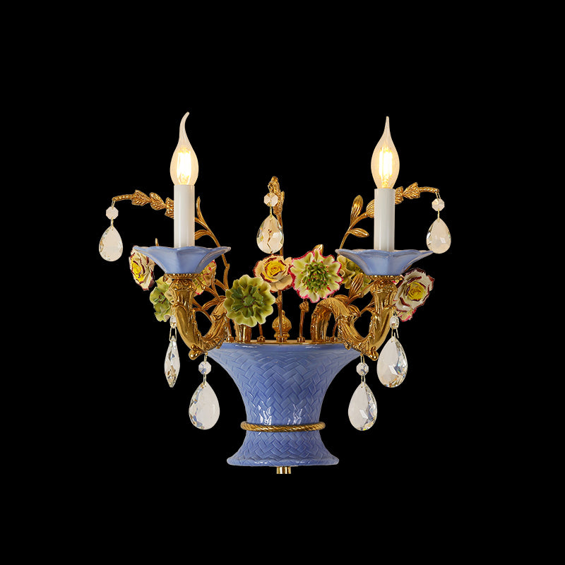 Front view of the Provence Ceramist brass wall lamp with blue ceramic vase, colorful flowers, and crystal drops on dark background.