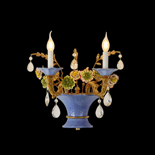 Front view of the Provence Ceramist brass wall lamp with blue ceramic vase, colorful flowers, and crystal drops on dark background.
