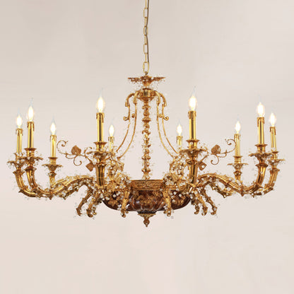 A lit European classical brass chandelier with golden finish and crystal accents against a light wall.