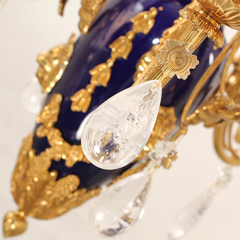 Extreme close-up of the deep blue ceramic urn with gold on a luxury brass chandelier.