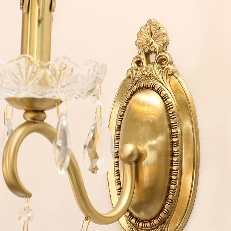 Macro detail of the sconce’s ornate brass backplate with intricate floral and scroll engravings.