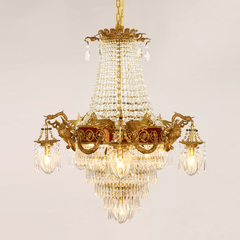 Victorian-style brass chandelier with red accents and intricate metalwork against black.