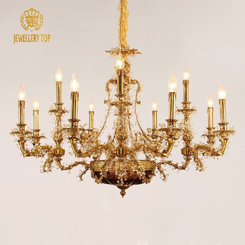 JEWELLERY TOP brand's ornate brass chandelier with symmetrical arms and crystal decorations.