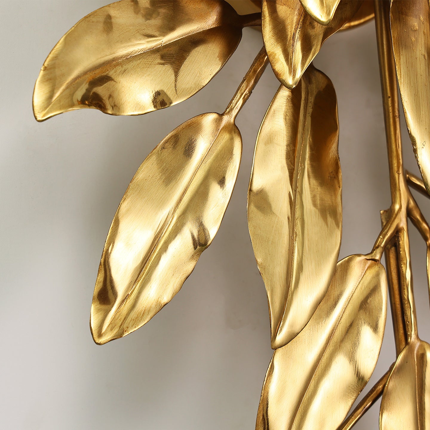 Extreme macro close-up of a single textured brass leaf, highlighting its realistic veins, polished surface, and golden glow.