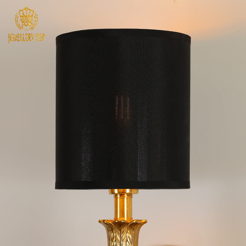 Side view of the wall light, highlighting the contrast between the polished brass arm and the matte black lampshade.