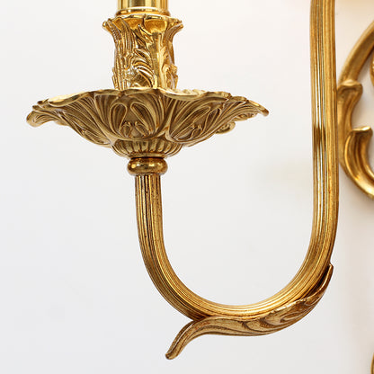 Detailed close-up of a single curved brass arm and bulb holder, highlighting the elegant craftsmanship of the sconce.