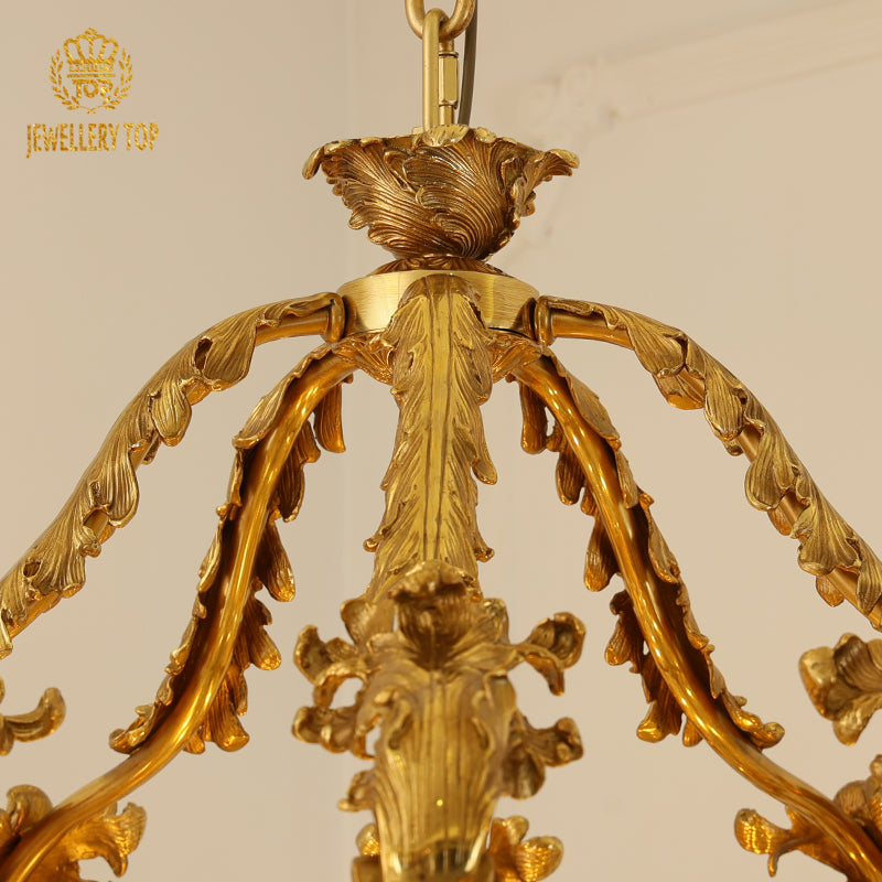 Top-down view of the intricate brass canopy and radiating arms of a classical chandelier.