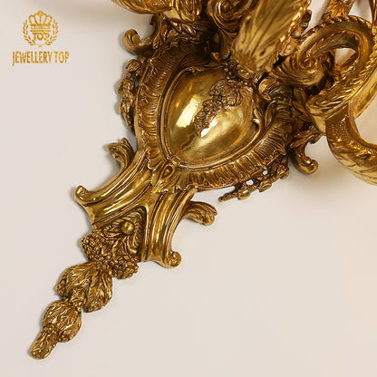 Close-up detail of the sconce’s ornate edge, showcasing complex scrollwork and classic European design elements.