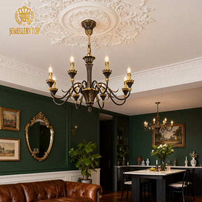 French vintage brass chandelier above a dining setting in a room with green walls and art.