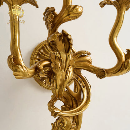 Close-up detail of hand-carved solid brass acanthus leaf scrollwork on The Chloris wall sconce by Jewellery Top.