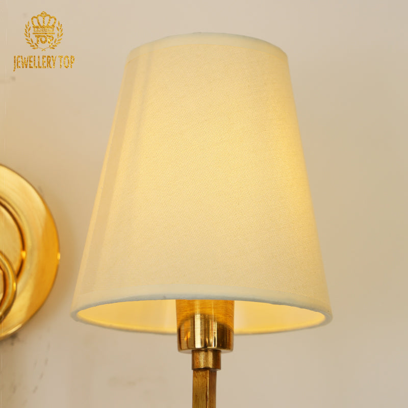 Detailed macro shot of the wall sconce’s circular brass mounting plate with a fine brushed metal texture.
