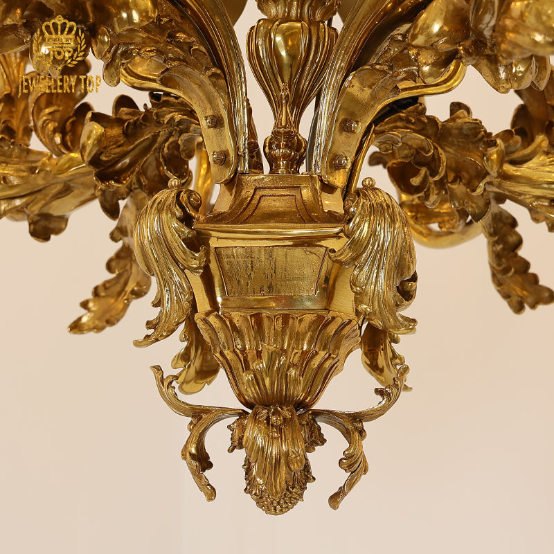 Detailed view of ornate brass central column with complex carvings on a classical chandelier.