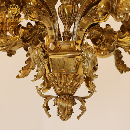 Detailed view of ornate brass central column with complex carvings on a classical chandelier.