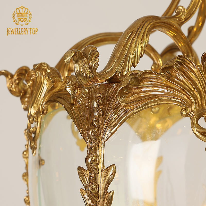 Extreme close-up of intricate brass engravings on a JEWELLERY TOP luxury pendant light.