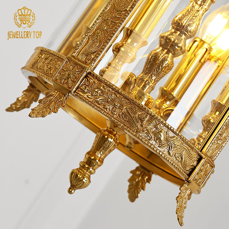Close-up of the brass pendant light’s glass panel, frame, and warm candle bulb glow.