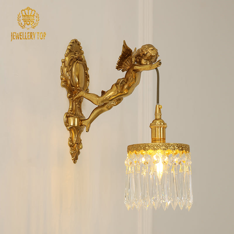 Close-up front view of the ornate antique brass sconce with a flying angel figure and glowing bulb.