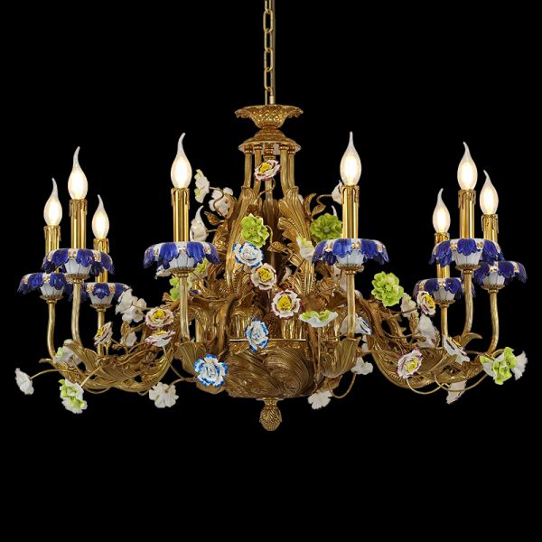 Golden brass chandelier decorated with blue, white, and green ceramic flowers, close-up view.