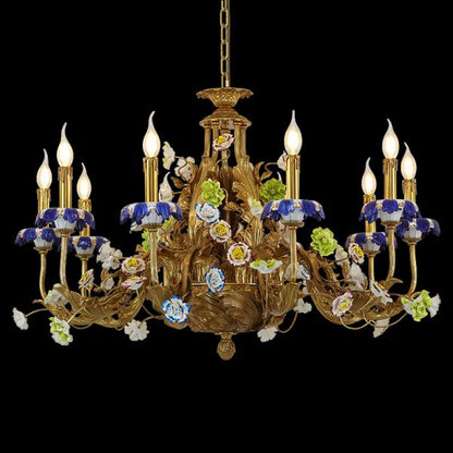 Golden brass chandelier decorated with blue, white, and green ceramic flowers, close-up view.
