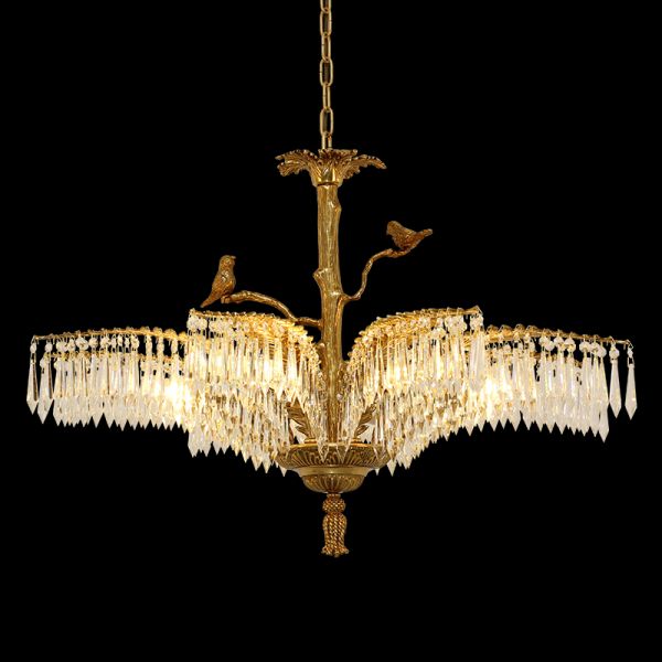 Close-up detail of antique brass chandelier with birds and layered crystal curtains.