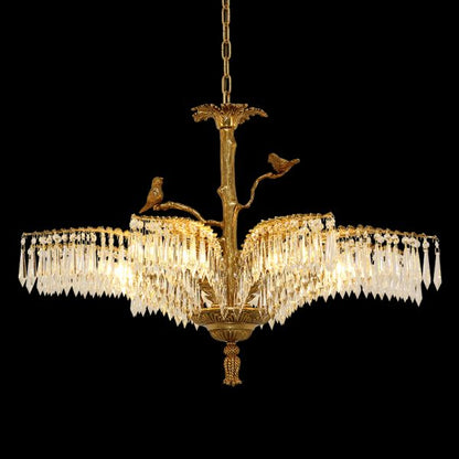 Full view of a luxurious crystal and brass chandelier with bird decorations, black background.
