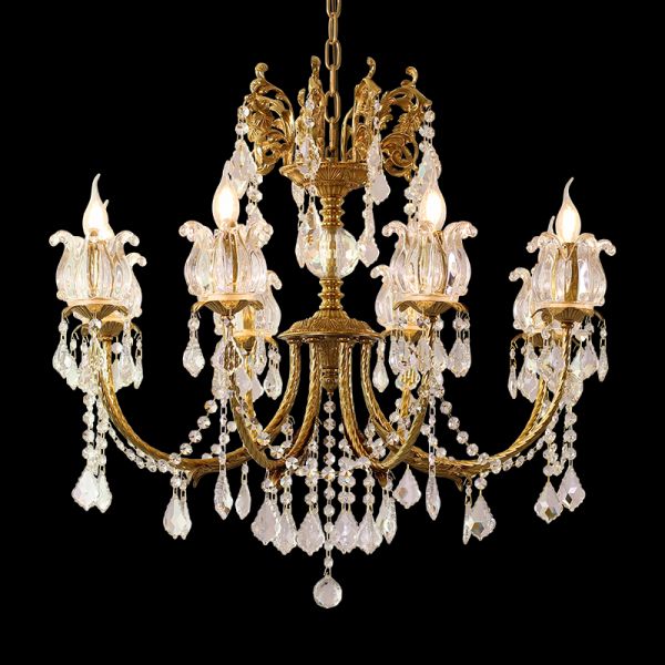 Close-up of a French brass chandelier’s dense crystal fringe and candle-style bulbs on black.