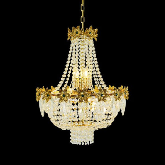 Full view of the French Floral Gem & Cascading Crystal brass chandelier glowing against a stark black background.