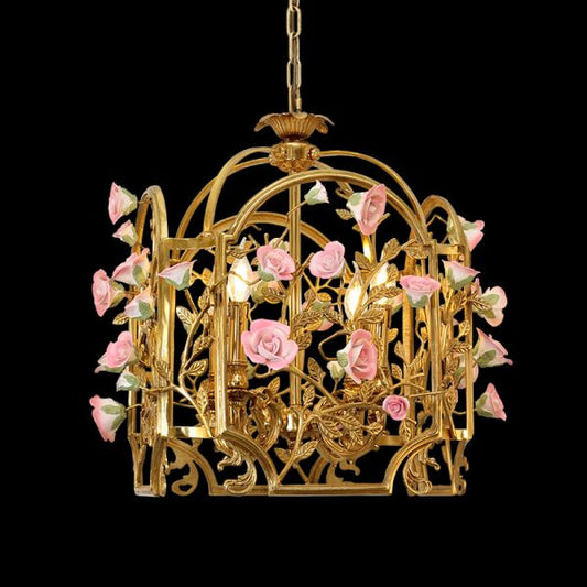Full view of the French Rose Garden cage brass chandelier adorned with cascading pink porcelain roses on a black background.