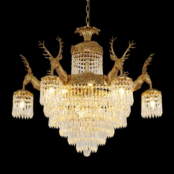 Full studio shot of the French Baroque deer head solid brass crystal chandelier glowing against a stark black background.