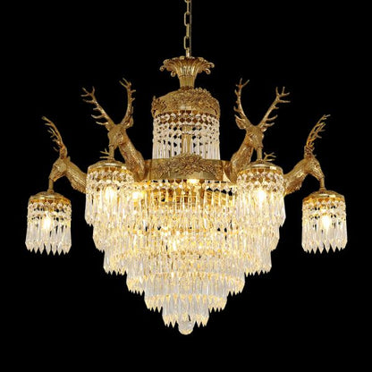 Full studio shot of the French Baroque deer head solid brass crystal chandelier glowing against a stark black background.