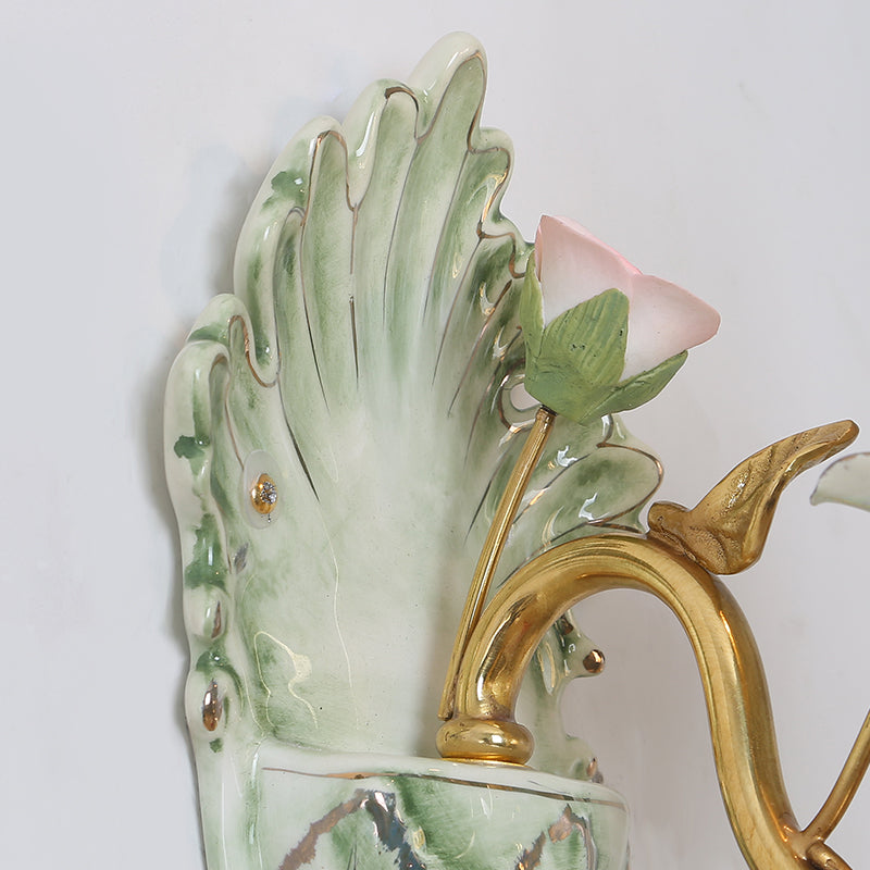 Product shot focusing on the contrast between the golden brass, green ceramic, and pink flowers.