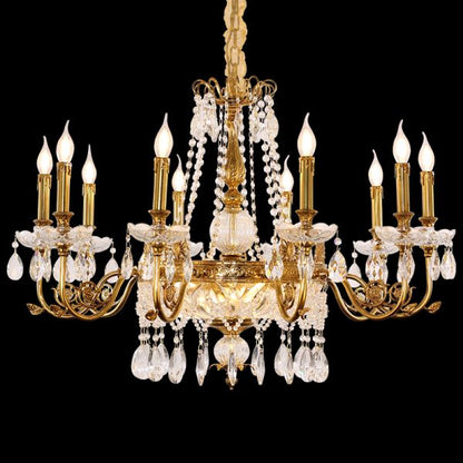 Close-up front view of a Baroque brass chandelier with flower crystal centerpiece on black.