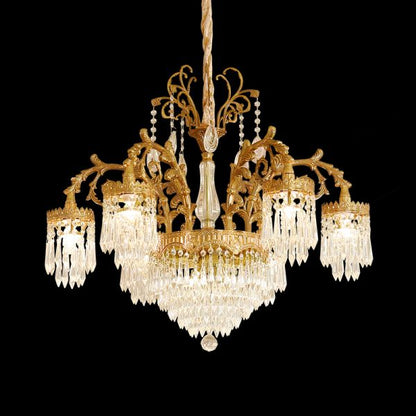 Front view of a golden Rococo brass chandelier with intricate metalwork and crystal droplets.