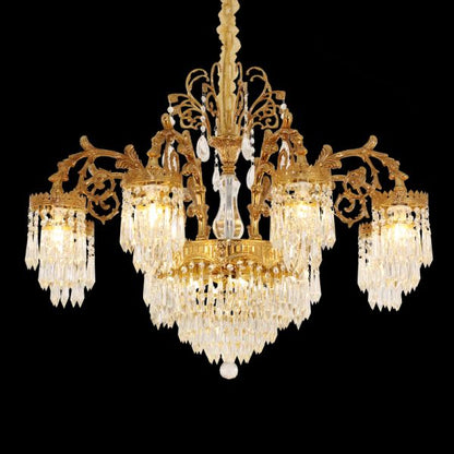 Detailed close-up of a luxurious brass chandelier with layered crystal fringes, black background.