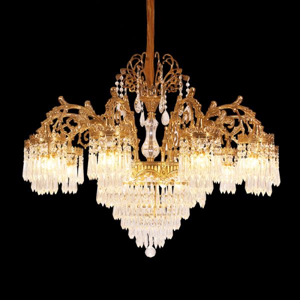 Side angle of a vintage European brass chandelier with scroll arms and crystal pendants.