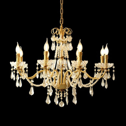A classical chandelier installed in a grand residential lobby with ornate wall moldings and a sweeping staircase.