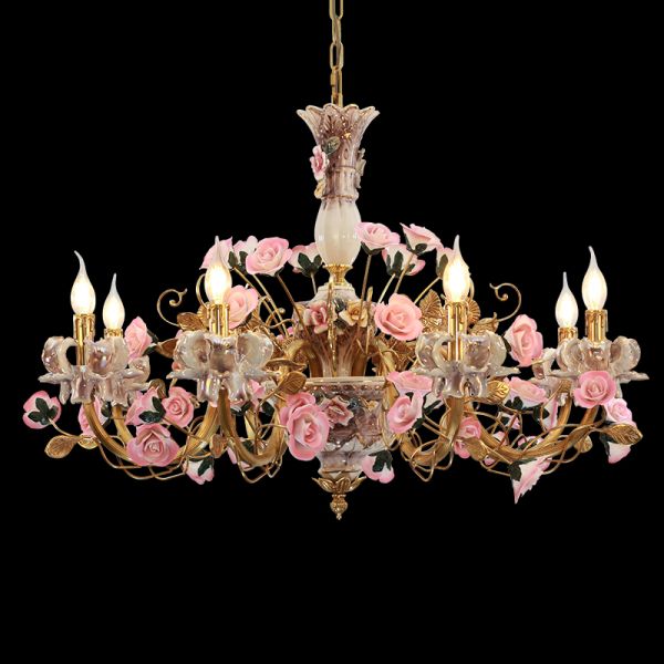 Lit French ceramic flowers chandelier with glowing candle bulbs and brass arms.