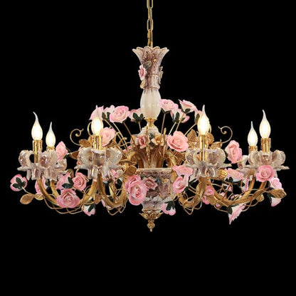 Lit French ceramic flowers chandelier with glowing candle bulbs and brass arms.