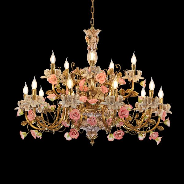 Detailed close-up of pink and white ceramic flowers on an ornate brass chandelier frame.