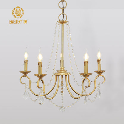Close-up detail of the polished brass arms and crystal drop accents on a decorative chandelier.