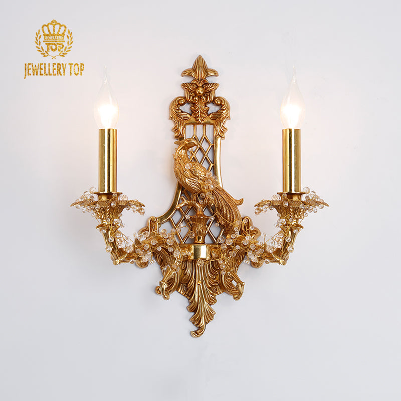 JEWELLERY TOP branded two-light brass sconce with detailed bird sculpture and openwork patterns.