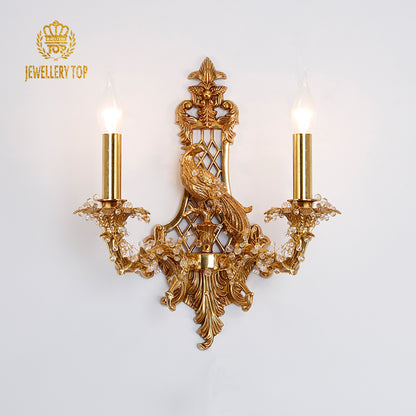 JEWELLERY TOP branded two-light brass sconce with detailed bird sculpture and openwork patterns.