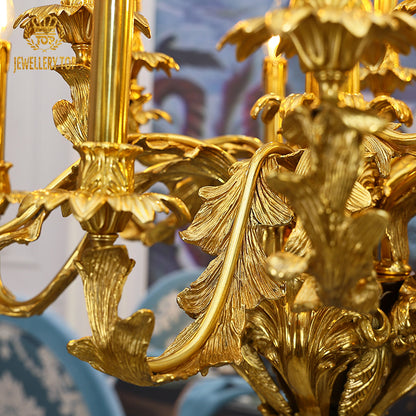 Extreme close-up of hand-carved brass leaf and floral details on a classical chandelier.
