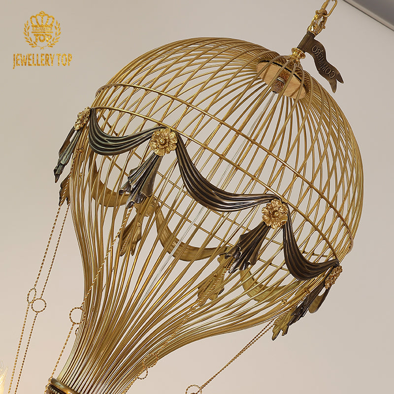 Top view of the JEWELLERY TOP brass chandelier's spherical cage with fabric and floral decor.