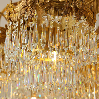 Close-up detail of K9 crystal pendants and golden brass scrollwork on a luxury chandelier.
