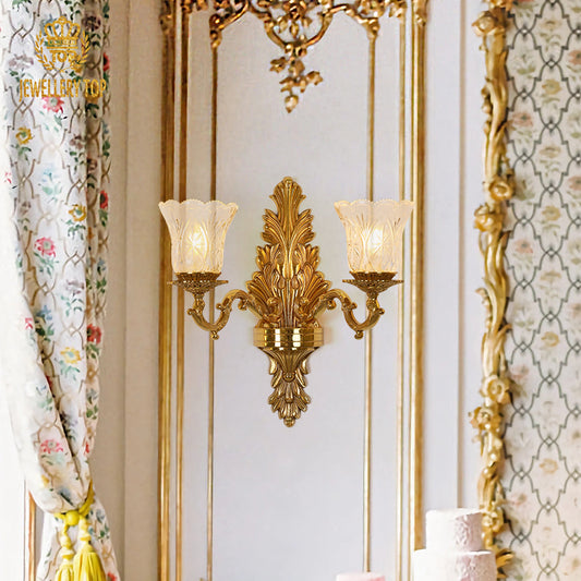 The French brass wall lamp installed beside floral curtains and ornate gold trim, emitting a warm ambient glow.